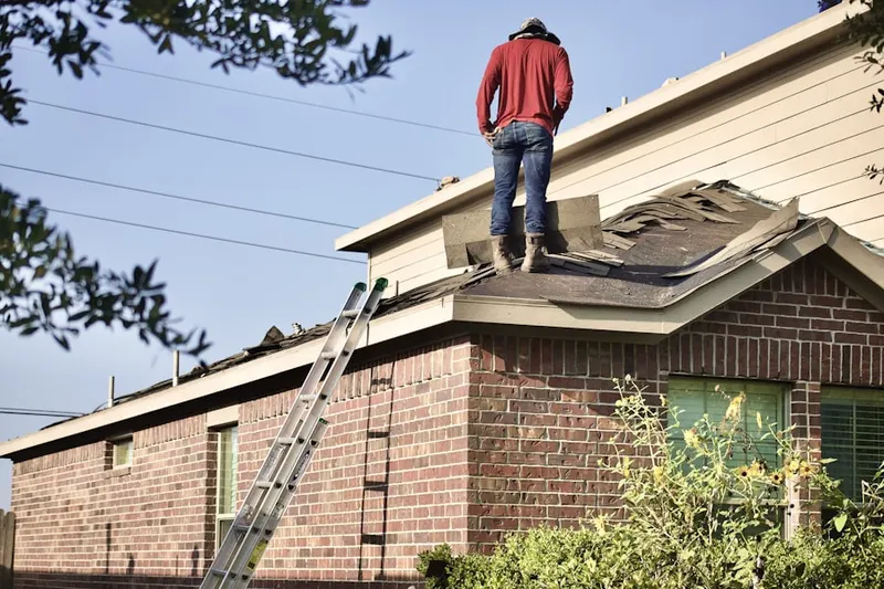 Professional roofer working on a residential roof in Acton